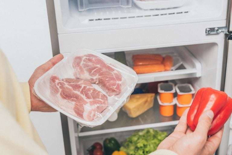男人拿着肉和新鲜灯笼椒附近打开冰箱里的食物、电冰箱直立冰箱不冻结,做什么呢?
