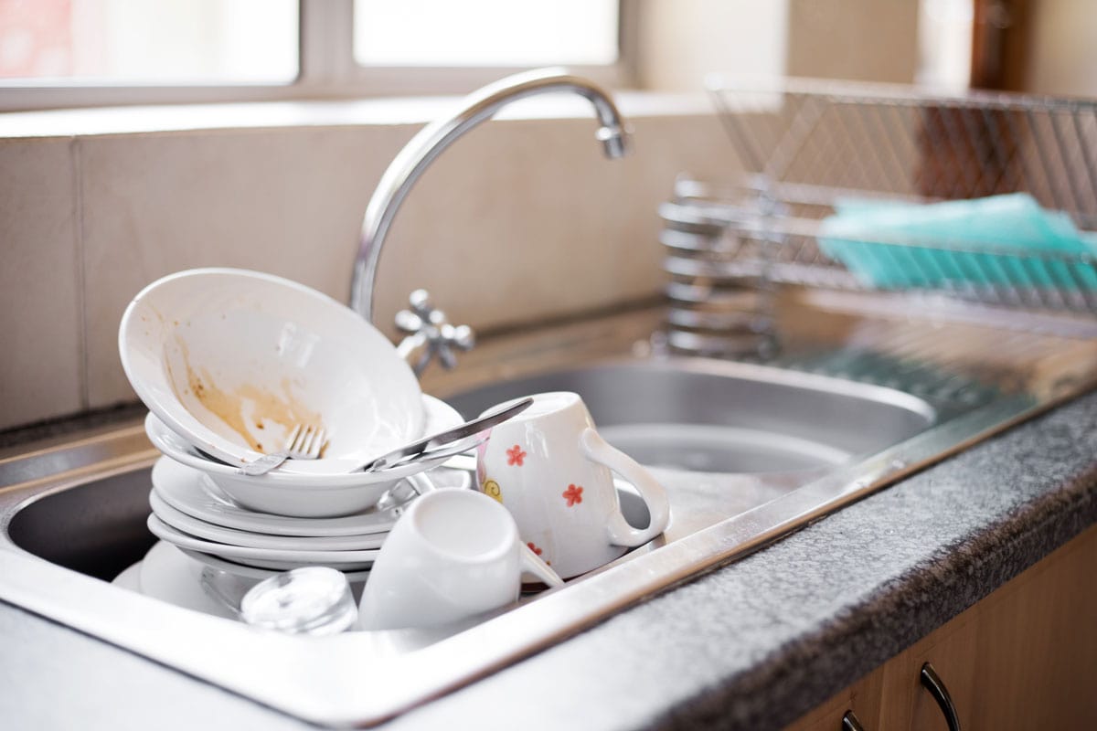 kitchen sink full of dirty dishes