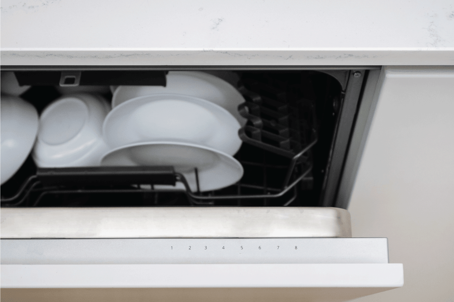 稍微打开洗碗机装满白色光滑的清洁用具和餐具