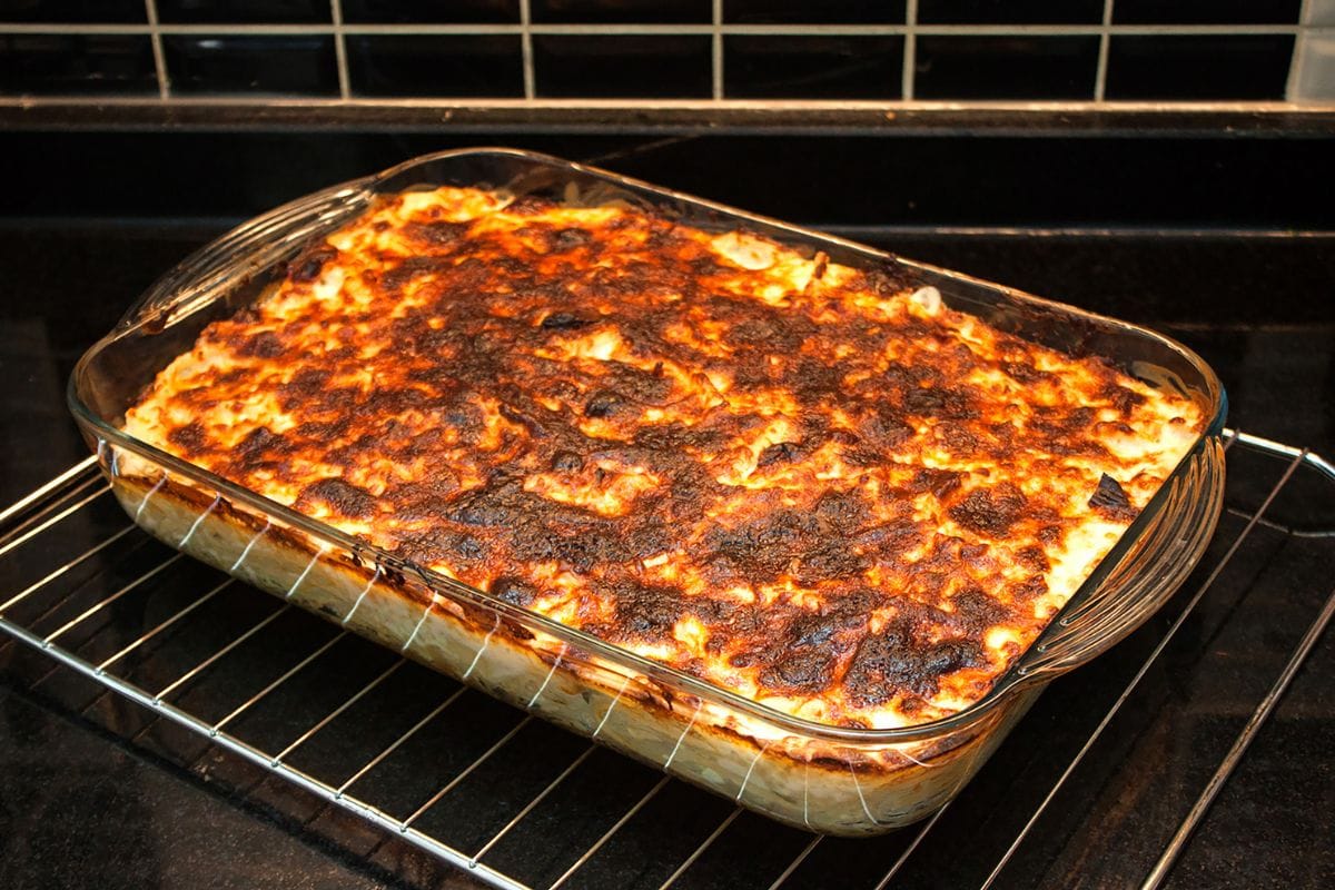 烤好的意大利面和融化的奶酪放在长方形的烤箱玻璃盘中