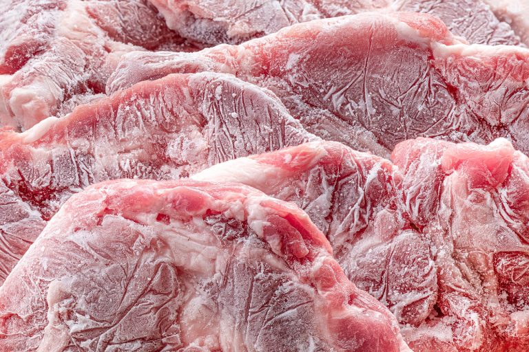 生的冷冻肉块。生猪排特写纹理。快速冷冻肉类产品——多久之前冻结肉磨或切片