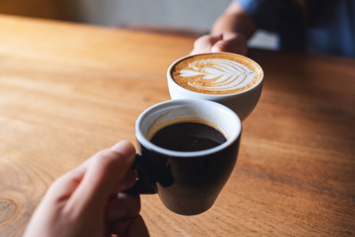 一个男人和一个女人无比的白色的咖啡杯在咖啡馆