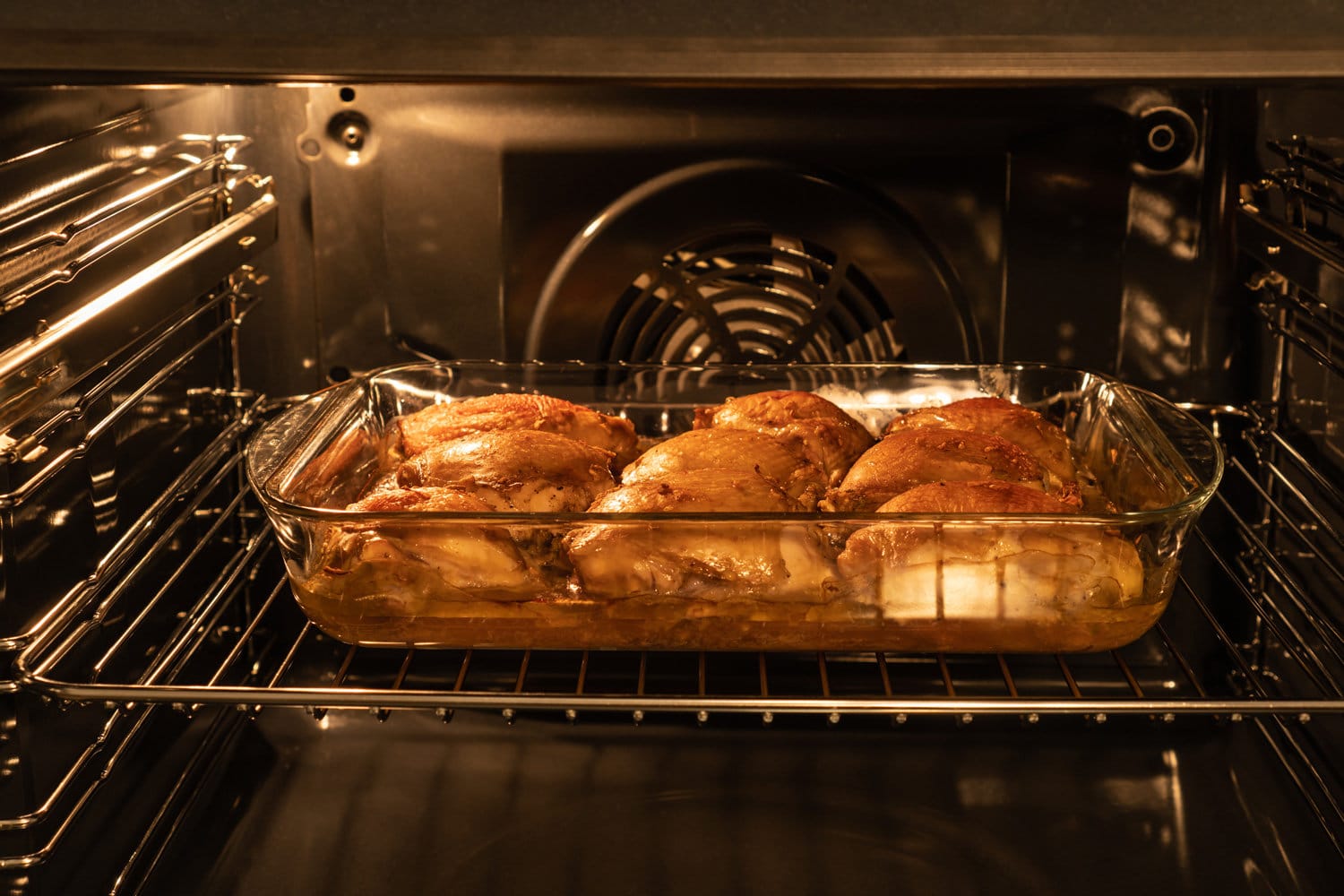 鸡腿在烤箱的玻璃锅里烤。自制的食物。