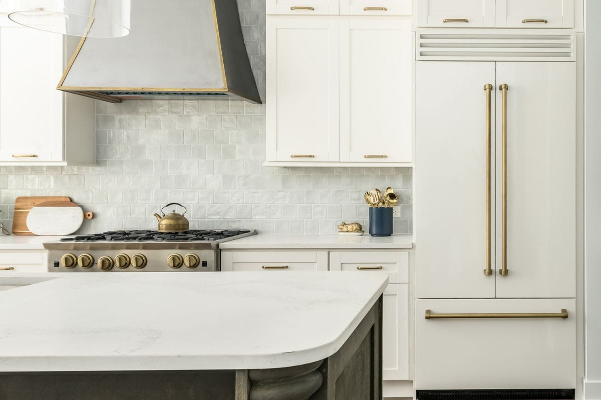 优雅的厨房设计，bd手机下载白色哑光冰箱，白色橱柜，和两个色调的厨房岛。灰瓦后挡板和金属抽油烟机。