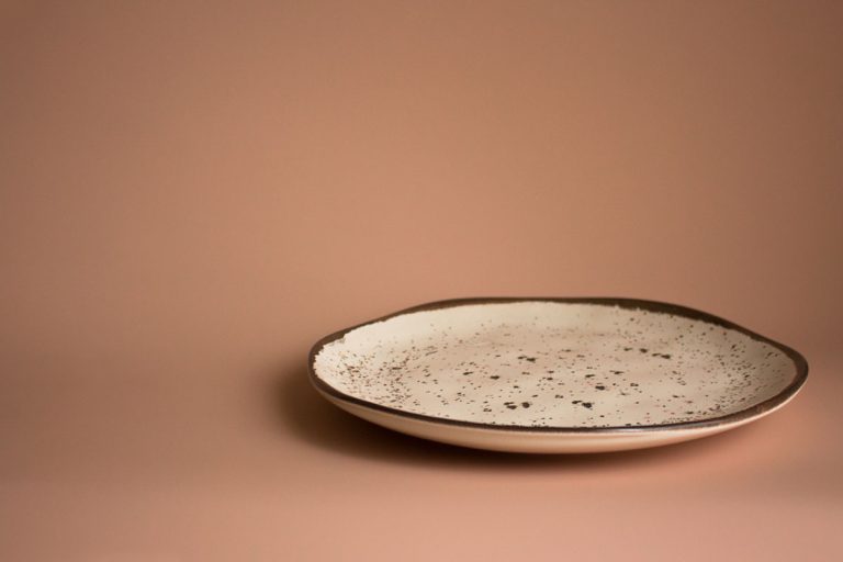 空的陶瓷板与孤立的棕色污点在尘土飞扬的粉红色,美国制造陶瓷餐具是什么?(11个选项可供选择)