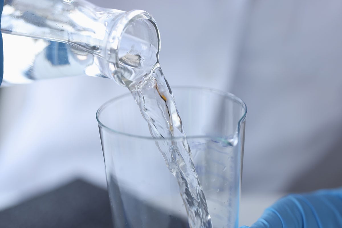 科学家化学家在实验室将水从透明瓶中倒入烧瓶中