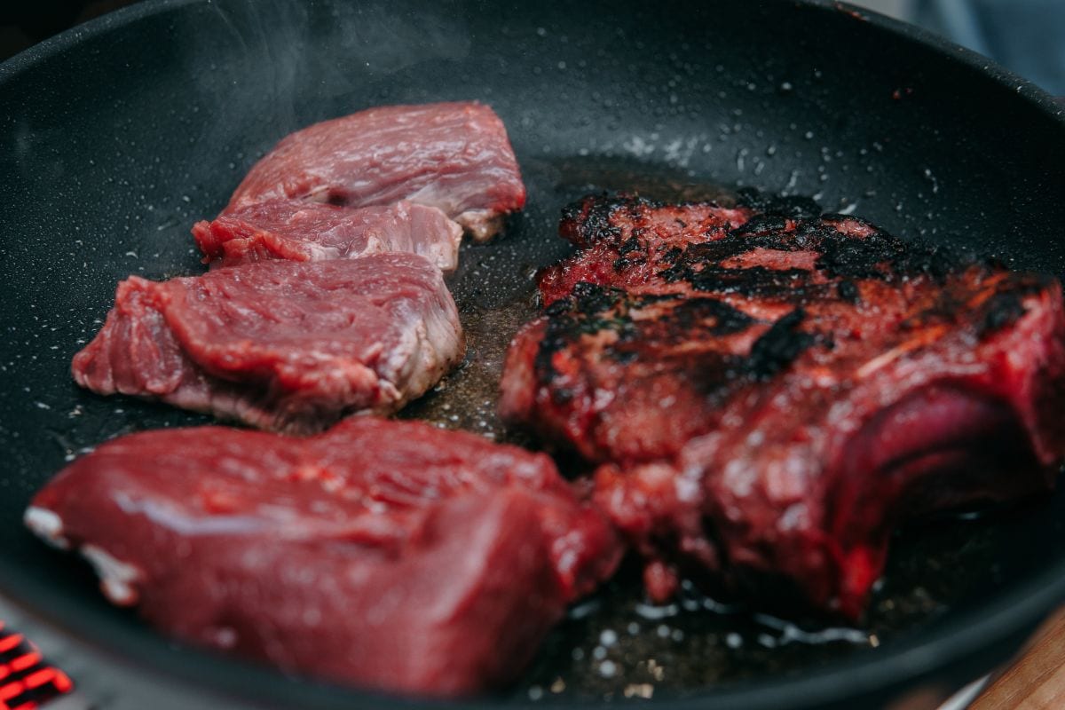 煮牛排用的生牛肉。在烹饪课上用煎锅烹饪肋眼牛排。烧牛排。在家做饭，自制食物。