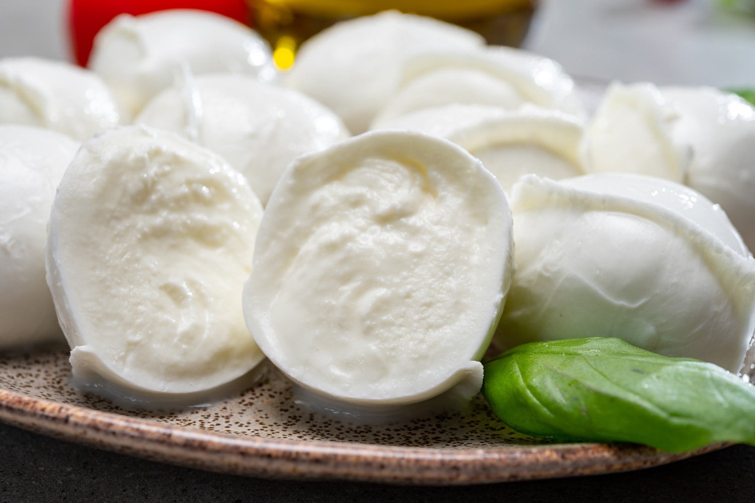 Tasty italian food, fresh white buffalo mozzarella soft cheese balls from Campania and tomatoes, fresh basil and olive oil, close up