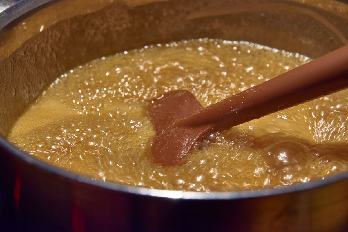 在锅中放入煮熟的糖、酱油、黄油和奶油的勺子，用来制作奶油糖