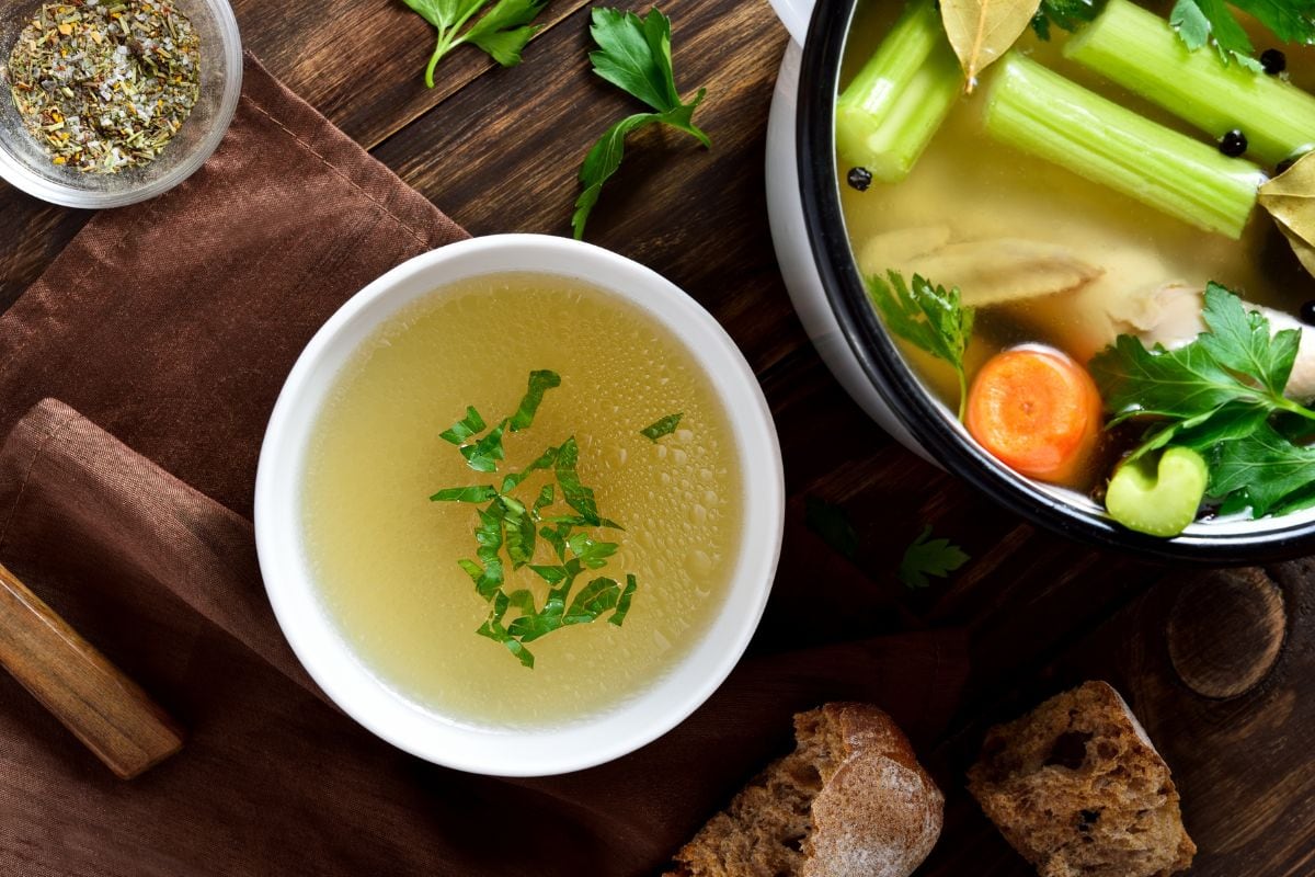 鸡肉汤与蔬菜和香料的木制背景。俯视图，平面布局