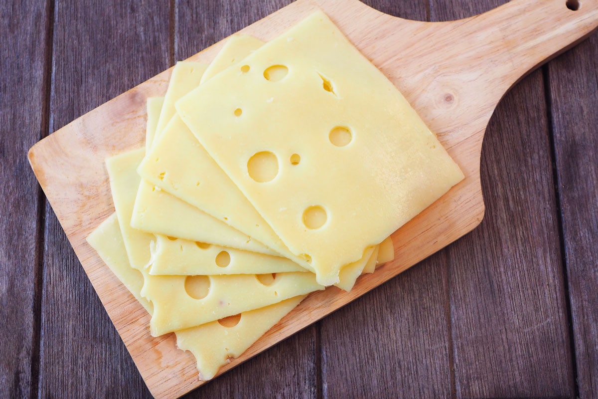 切成薄片的瑞士奶酪放在案板上