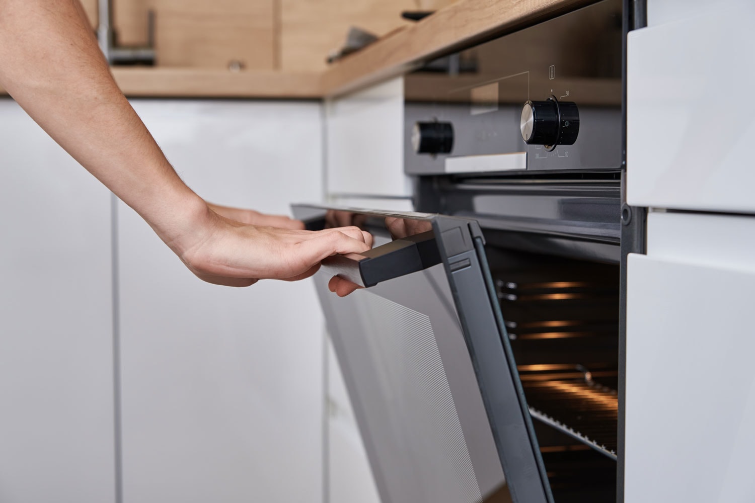 女人用手打开电烤箱门。自制的烹饪。bd手机下载厨房电器