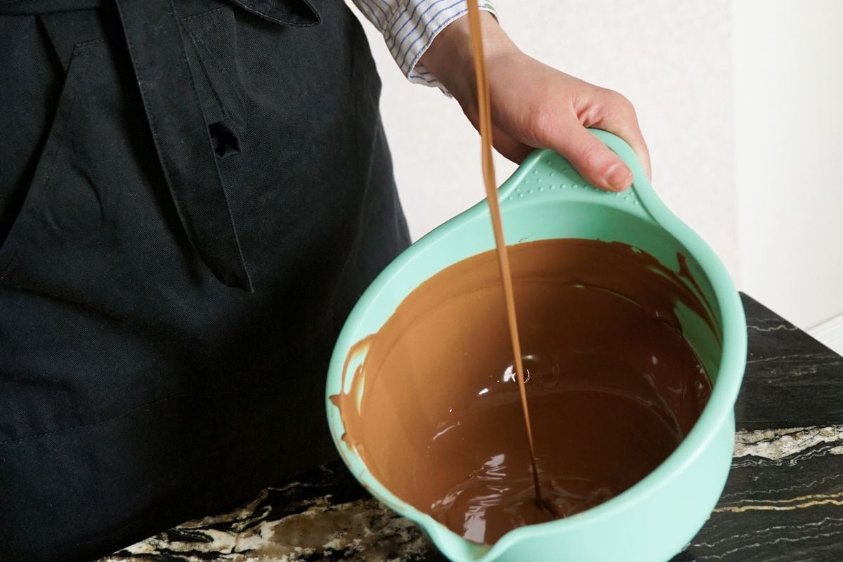 一名女子搅拌巧克力制作自制巧克力。糖果制作，糕点制作，烘焙，甜点概念。