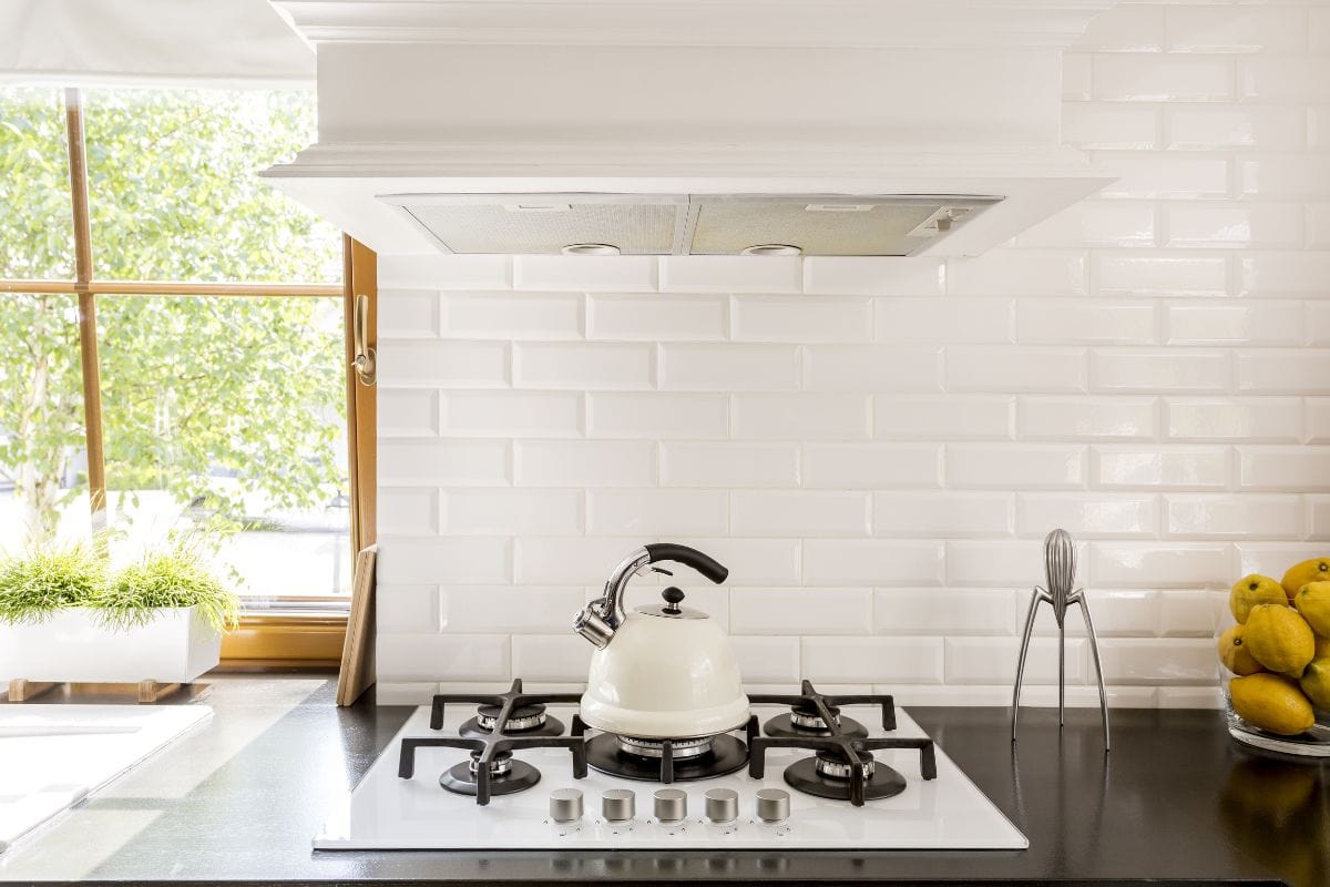 新风格的厨房与黑暗的bd手机下载工作台,白色的煤气炉和装饰砖连壁
